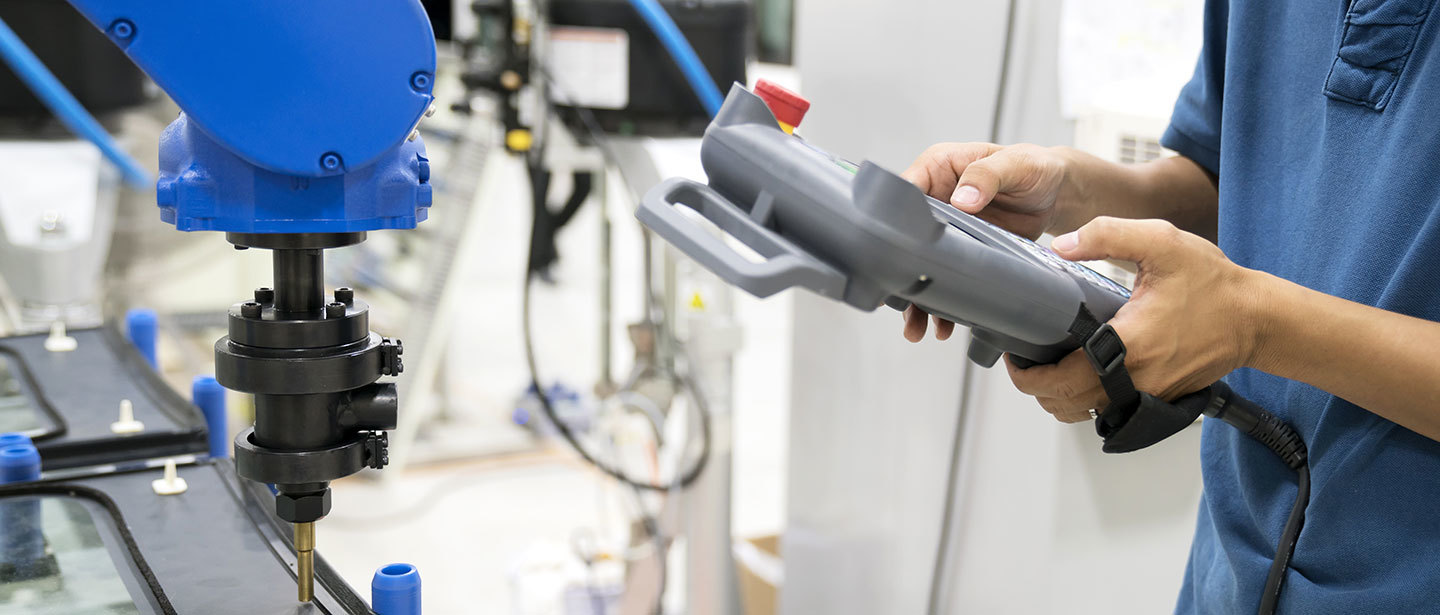 An operator using a handheld scanner, in a factory